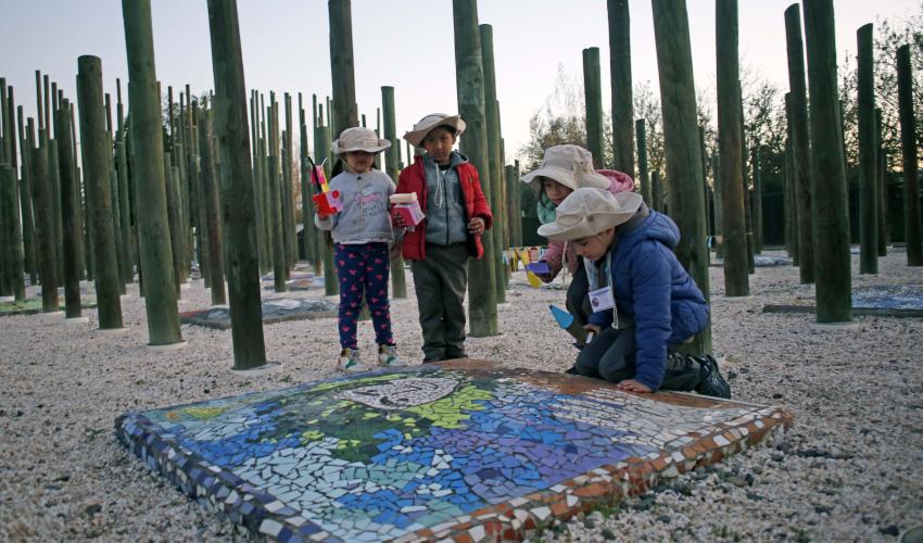 Niños juegan con origamis y observan un mosaico 