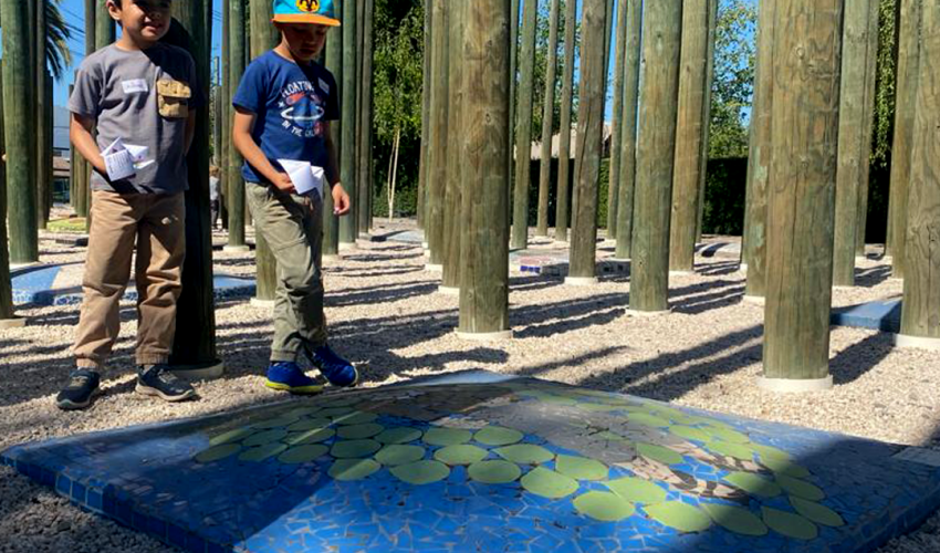 Niños juegan con origamis y observan un mosaico