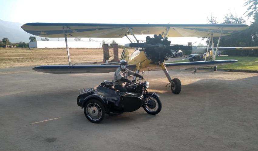 Moto con sidecar junto a Avión Sterman