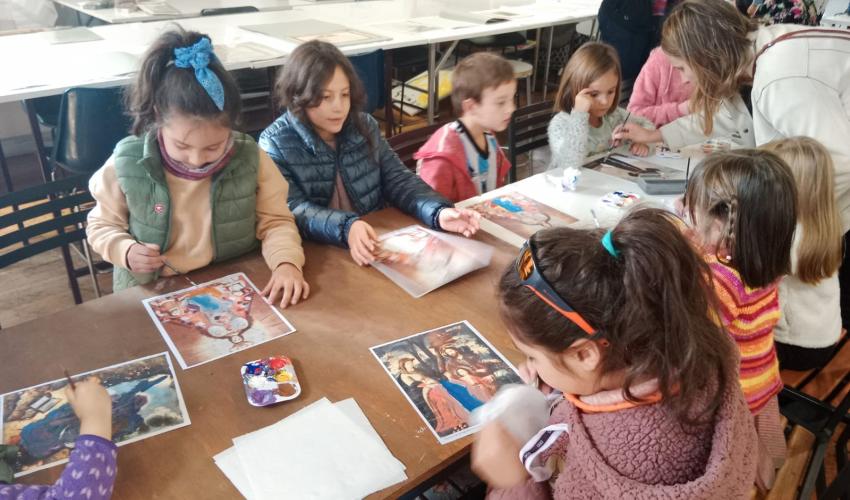 Niños y niñas añaden color a un cuadro antiguo